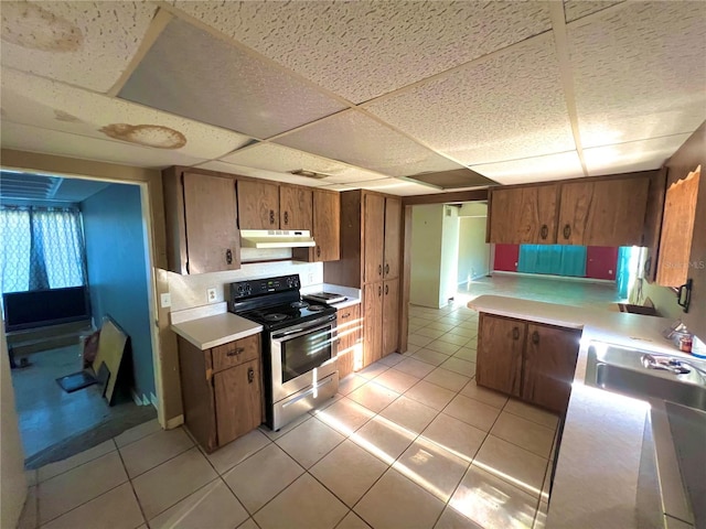 1221 Oak Haven Dr, Altamonte Springs, FL 32714 - kitchen featuring brown cabinets, light countertops, stainless steel range with electric stovetop, and under cabinet range hood