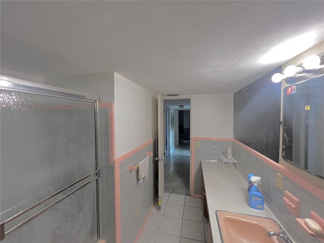 1221 Oak Haven Dr, Altamonte Springs, FL 32714 - bathroom with tile patterned floors, a sink, a stall shower, tile walls, and wainscoting