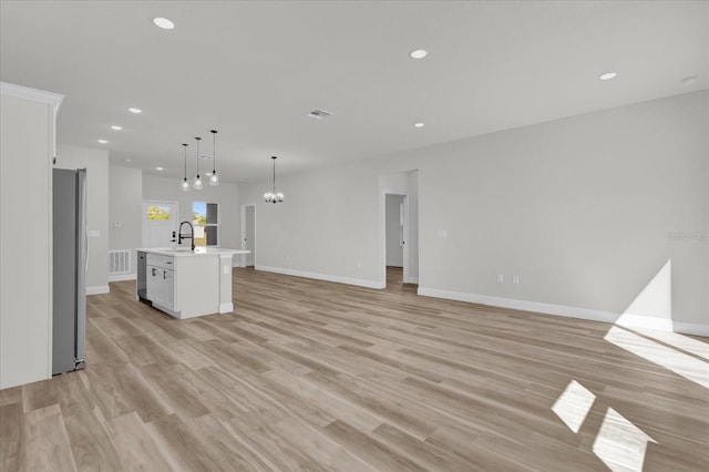 15823 SW 27th Avenue Rd, Ocala, FL 34473 - unfurnished living room featuring recessed lighting, baseboards, a notable chandelier, and light wood-type flooring