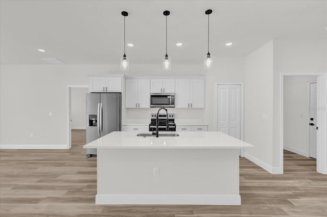 15823 SW 27th Avenue Rd, Ocala, FL 34473 - kitchen with baseboards, white cabinets, a center island with sink, and stainless steel appliances