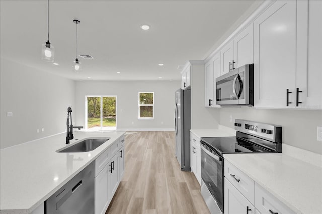 15823 SW 27th Avenue Rd, Ocala, FL 34473 - kitchen with recessed lighting, white cabinetry, a sink, light wood finished floors, and appliances with stainless steel finishes