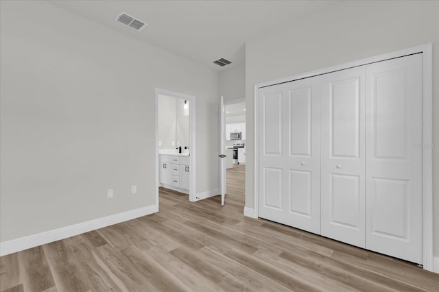 15823 SW 27th Avenue Rd, Ocala, FL 34473 - unfurnished bedroom featuring baseboards, light wood finished floors, ensuite bath, and visible vents