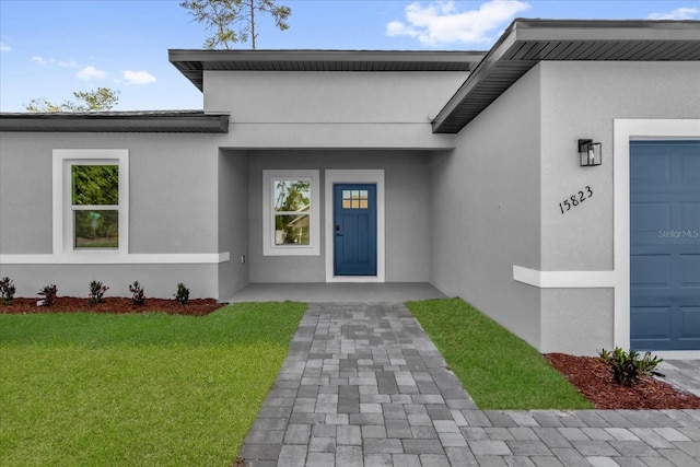 15823 SW 27th Avenue Rd, Ocala, FL 34473 - doorway to property with a garage, stucco siding, and a yard