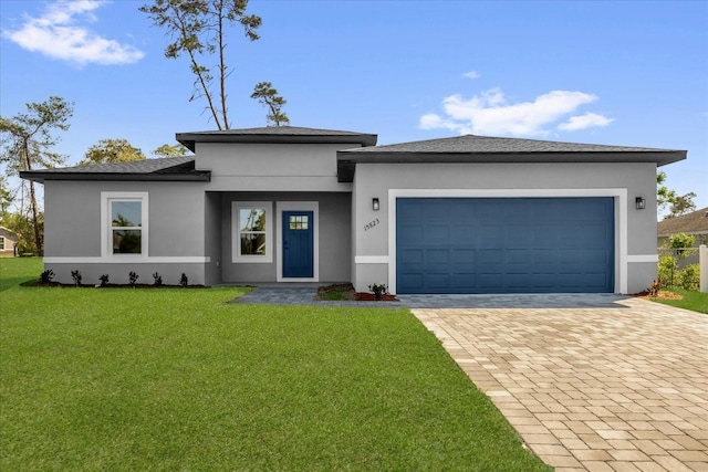 15823 SW 27th Avenue Rd, Ocala, FL 34473 - prairie-style home with an attached garage, decorative driveway, stucco siding, and a front yard