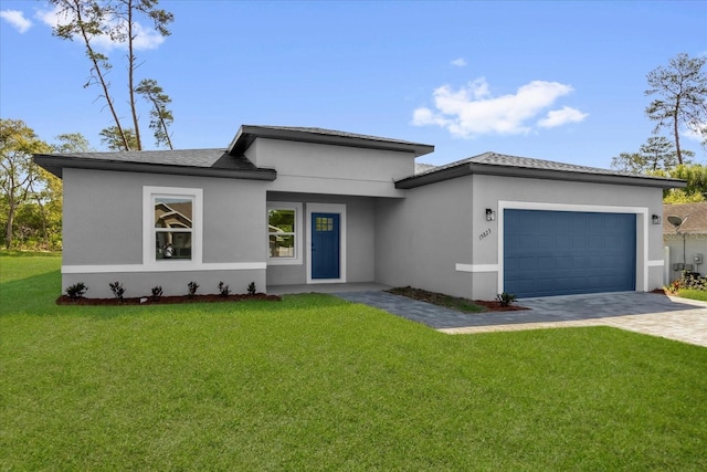 15823 SW 27th Avenue Rd, Ocala, FL 34473 - prairie-style home featuring a garage, stucco siding, decorative driveway, and a front lawn
