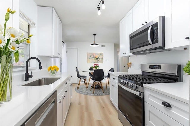 730 Georgia Ave, Longwood, FL 32750 - kitchen featuring light wood finished floors, stainless steel appliances, light countertops, and a sink