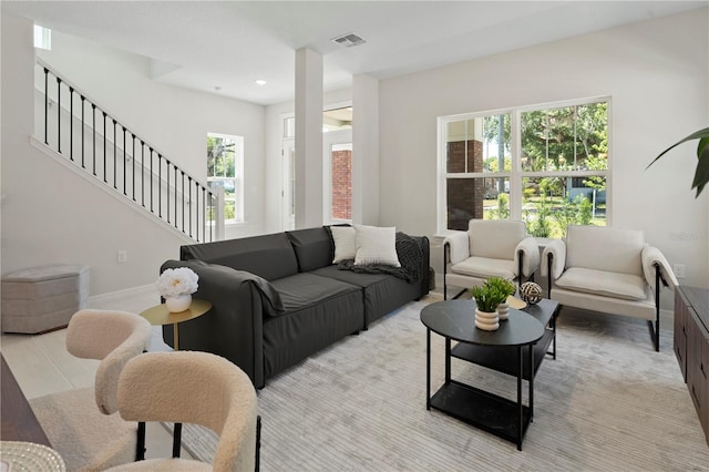 living area with recessed lighting, baseboards, visible vents, and stairs