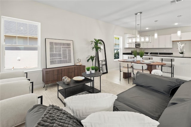 living room with baseboards, visible vents, and recessed lighting