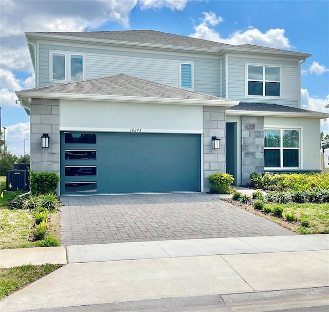 10275 Park Estates Ave, Orlando, FL 32836 - view of front facade featuring decorative driveway, an attached garage, and stone siding