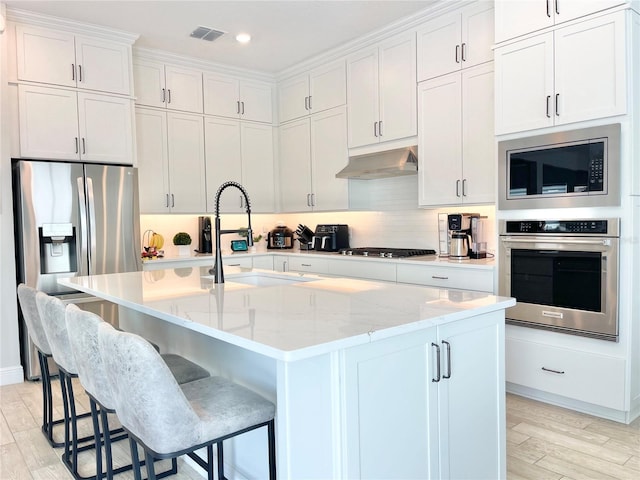 10275 Park Estates Ave, Orlando, FL 32836 - kitchen with visible vents, appliances with stainless steel finishes, a sink, white cabinets, and under cabinet range hood