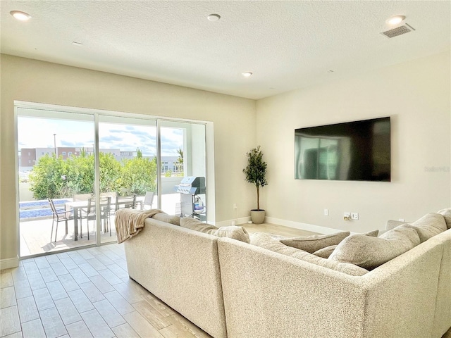 10275 Park Estates Ave, Orlando, FL 32836 - living room with a textured ceiling, visible vents, baseboards, light wood-style floors, and recessed lighting