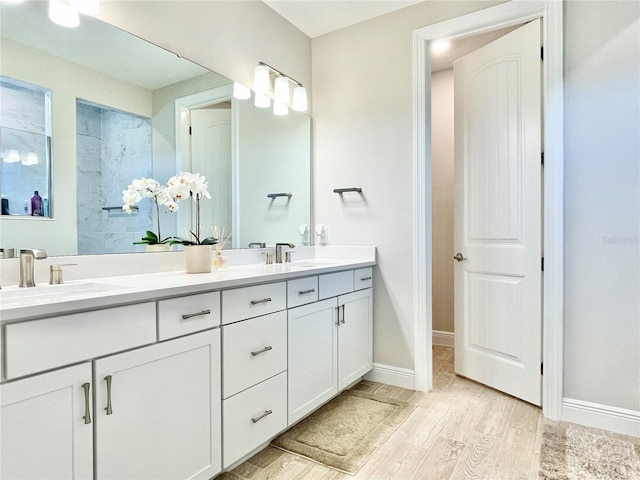 10275 Park Estates Ave, Orlando, FL 32836 - full bathroom with a tile shower, a sink, double vanity, baseboards, and wood finished floors