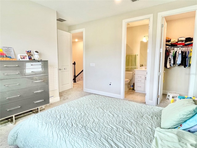 10275 Park Estates Ave, Orlando, FL 32836 - bedroom featuring light colored carpet, ensuite bath, baseboards, a spacious closet, and visible vents