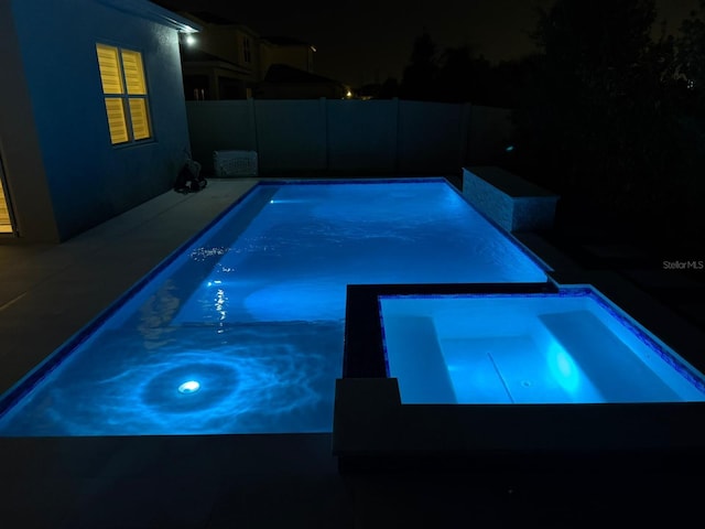 10275 Park Estates Ave, Orlando, FL 32836 - pool at night with a pool with connected hot tub and fence