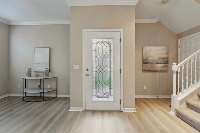 foyer entrance with baseboards, wood finished floors, and stairway