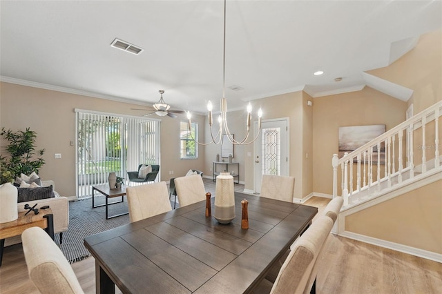dining room featuring visible vents, crown molding, light wood-type flooring, baseboards, and stairs