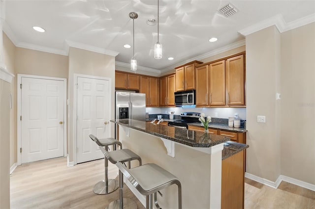 kitchen with stainless steel appliances, a breakfast bar, brown cabinetry, and light wood-type flooring