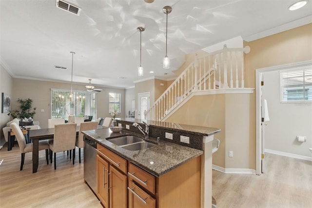 kitchen featuring visible vents, a sink, light wood-style floors, and brown cabinets