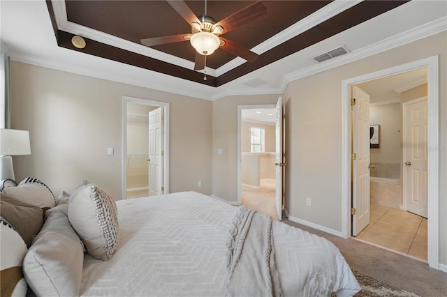 carpeted bedroom with visible vents, crown molding, a raised ceiling, baseboards, and connected bathroom