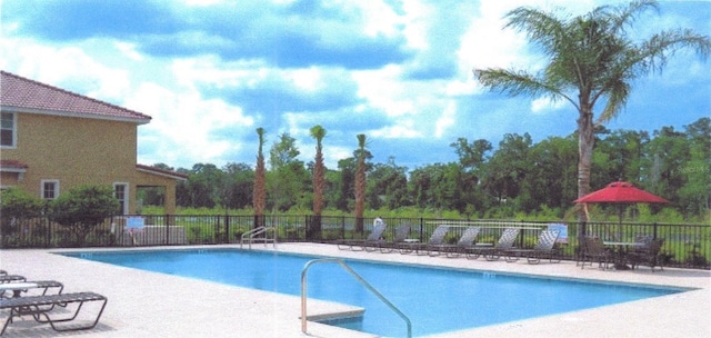 pool with a patio and fence