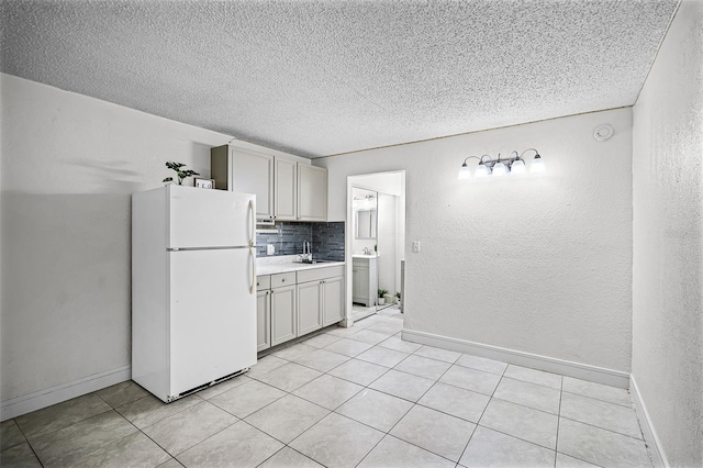 43420 Hwy 27 Unit 121, Davenport, FL 33837 - kitchen with a sink, light countertops, a textured ceiling, freestanding refrigerator, and tasteful backsplash