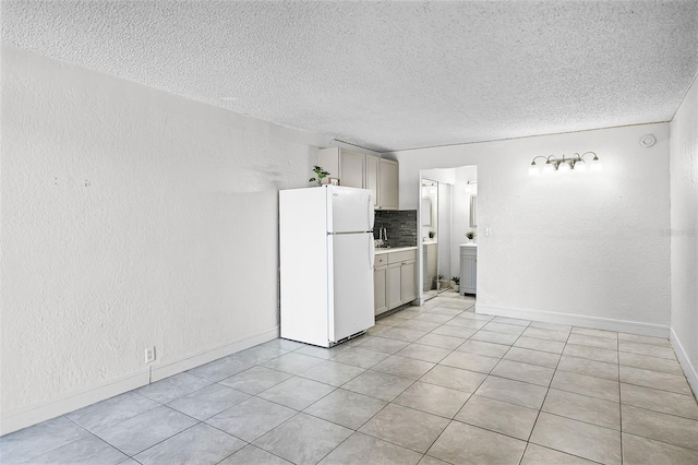 43420 Hwy 27 Unit 121, Davenport, FL 33837 - kitchen with gray cabinetry, decorative backsplash, freestanding refrigerator, and a textured ceiling