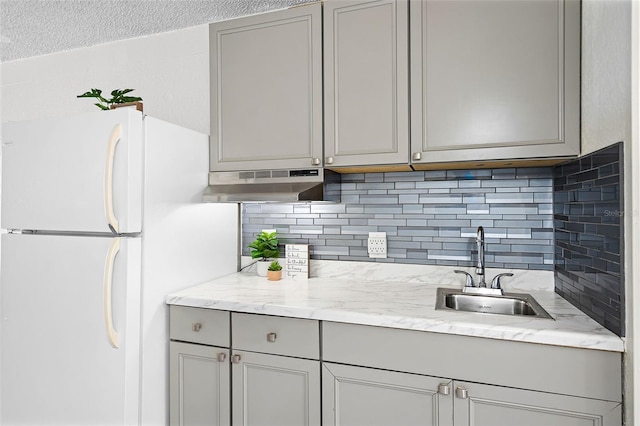 43420 Hwy 27 Unit 121, Davenport, FL 33837 - kitchen with decorative backsplash, gray cabinets, a sink, freestanding refrigerator, and under cabinet range hood