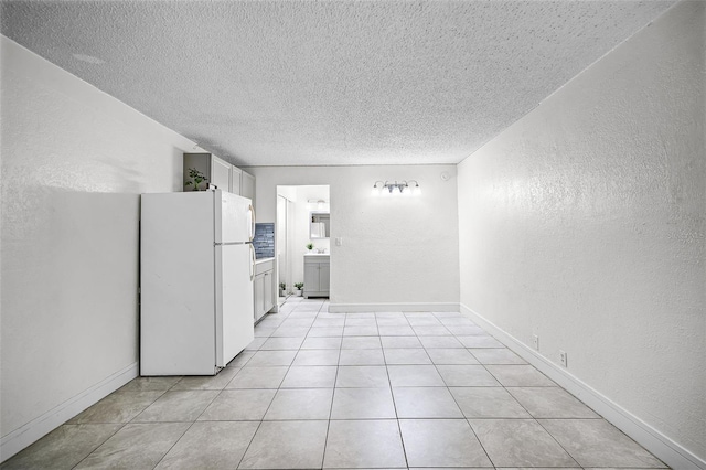 43420 Hwy 27 Unit 121, Davenport, FL 33837 - spare room with a textured ceiling, a textured wall, light tile patterned floors, and baseboards