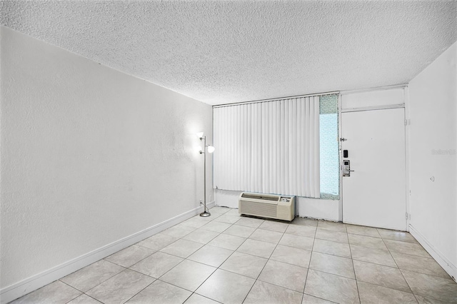 43420 Hwy 27 Unit 121, Davenport, FL 33837 - unfurnished room with a textured ceiling, light tile patterned floors, a wall unit AC, and baseboards