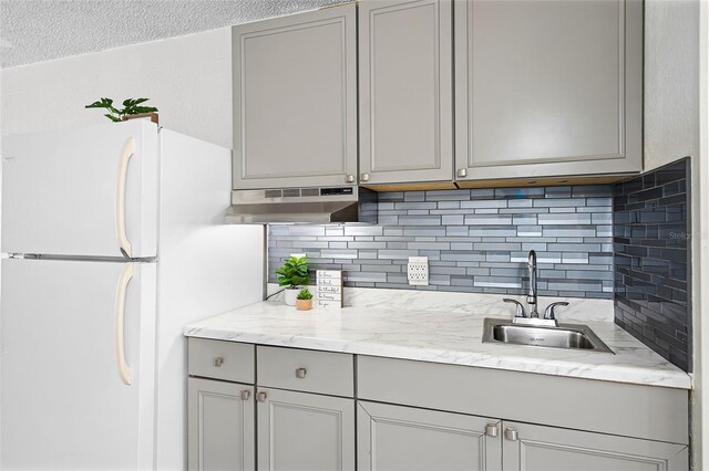 43420 Hwy 27 Unit 121, Davenport, FL 33837 - kitchen featuring a sink, freestanding refrigerator, gray cabinetry, under cabinet range hood, and decorative backsplash