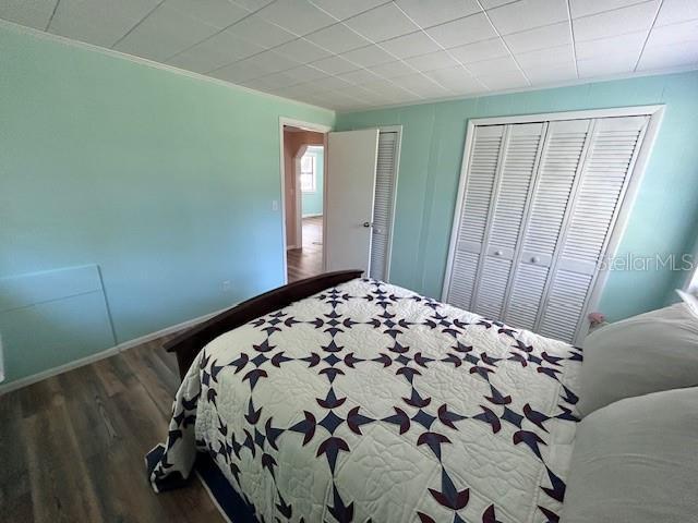 bedroom featuring baseboards and wood finished floors