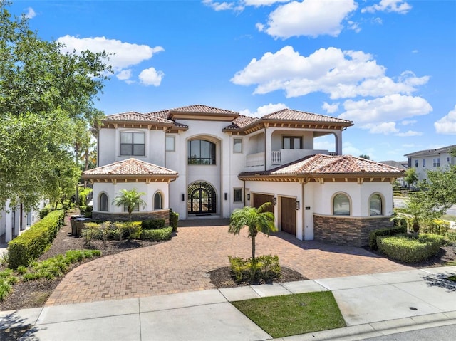 971 Golden Bear Dr, Reunion, FL 34747 - mediterranean / spanish-style house featuring french doors, a tile roof, a balcony, stucco siding, and decorative driveway