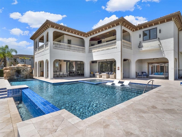 971 Golden Bear Dr, Reunion, FL 34747 - back of house with a balcony, an outdoor hangout area, and an in ground hot tub