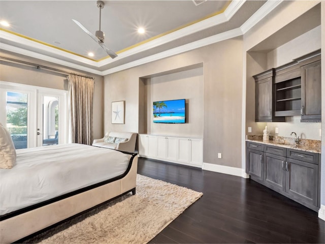 971 Golden Bear Dr, Reunion, FL 34747 - bedroom with baseboards, ornamental molding, a tray ceiling, and dark wood-style flooring