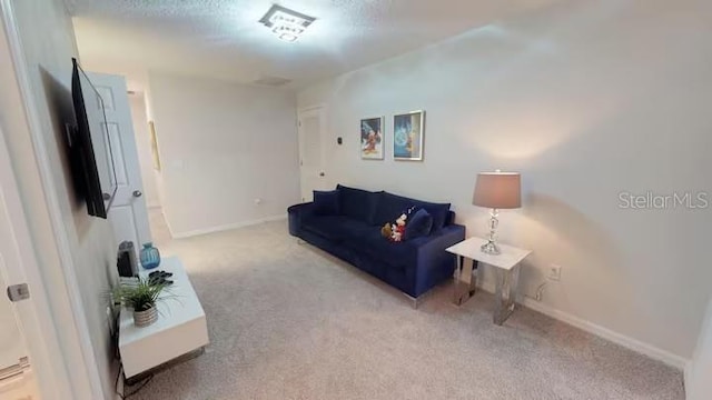 carpeted living area with baseboards