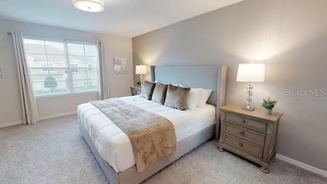 bedroom featuring light carpet and baseboards