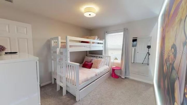 bedroom with baseboards, visible vents, and light colored carpet