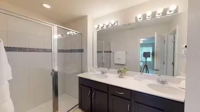 bathroom with a shower stall, a sink, and double vanity