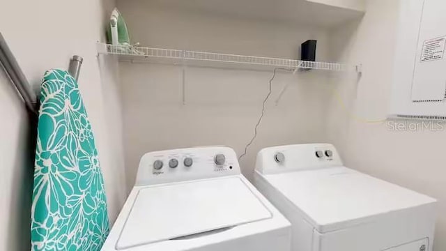 clothes washing area with washing machine and clothes dryer and laundry area