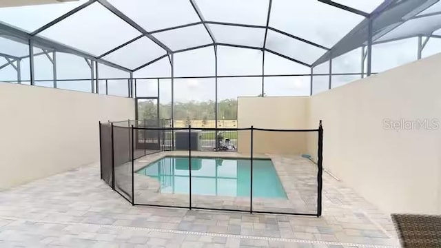 pool featuring glass enclosure and a patio
