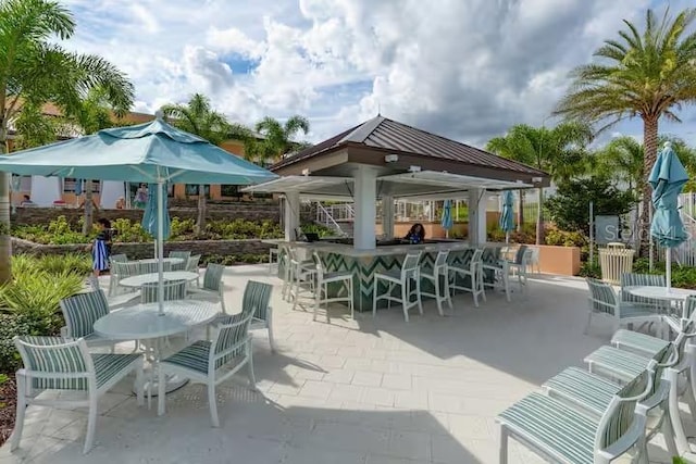 view of patio featuring outdoor dining area, outdoor dry bar, and a gazebo