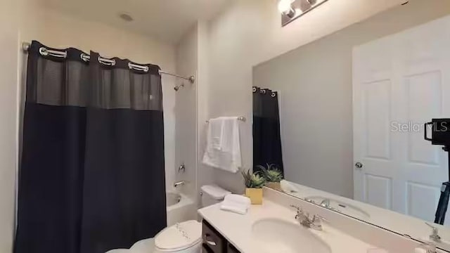 full bath with toilet, vanity, and shower / bath combo with shower curtain