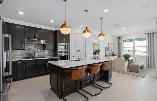 2741 Serenity Meadow Dr, Kissimmee, FL 34744 - kitchen with tasteful backsplash, a sink, appliances with stainless steel finishes, light countertops, and under cabinet range hood