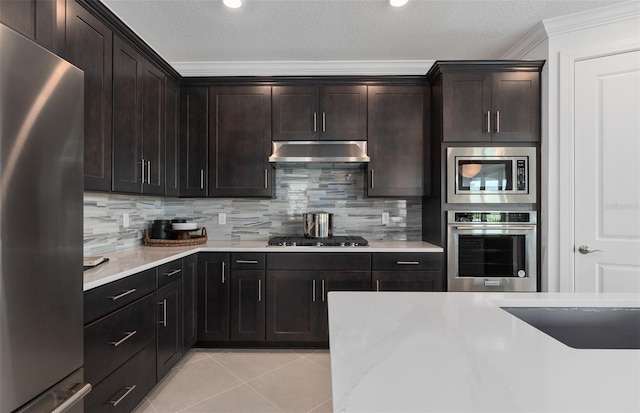 2741 Serenity Meadow Dr, Kissimmee, FL 34744 - kitchen with crown molding, decorative backsplash, appliances with stainless steel finishes, light countertops, and under cabinet range hood