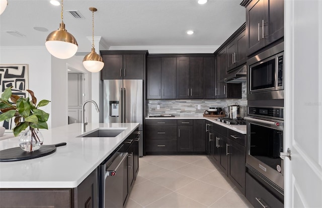 2741 Serenity Meadow Dr, Kissimmee, FL 34744 - kitchen with under cabinet range hood, stainless steel appliances, light countertops, ornamental molding, and a sink