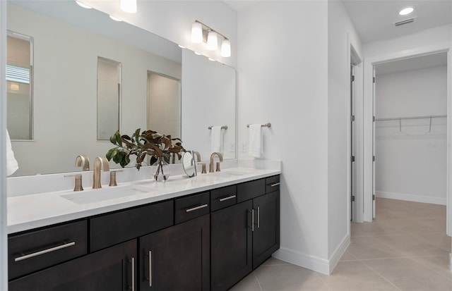 2741 Serenity Meadow Dr, Kissimmee, FL 34744 - bathroom with double vanity, a spacious closet, tile patterned floors, and a sink