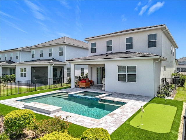 rear view of property featuring stucco siding, a tile roof, a patio, and a fenced backyard