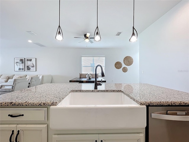 kitchen with light stone countertops, a sink, ceiling fan, dishwasher, and open floor plan