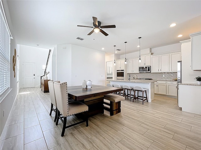 dining space with wood finish floors, recessed lighting, ceiling fan, and visible vents