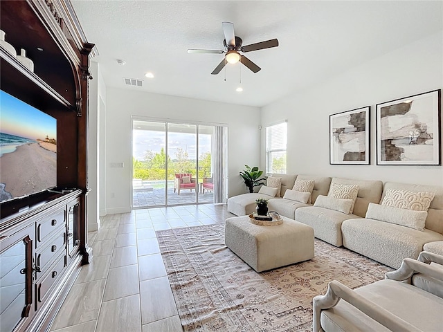 living area featuring light tile patterned floors, visible vents, ceiling fan, baseboards, and recessed lighting